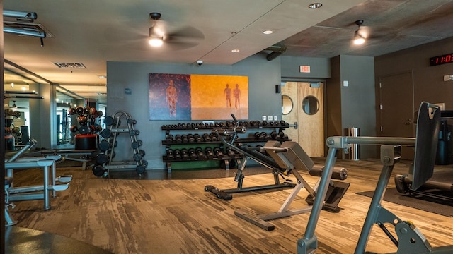 exercise room with visible vents, ceiling fan, and wood finished floors