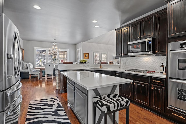 kitchen with a sink, stainless steel appliances, dark wood-type flooring, and a wealth of natural light