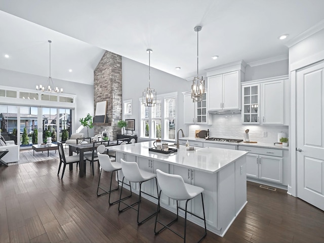 kitchen featuring a kitchen bar, light countertops, stainless steel gas stovetop, and a chandelier