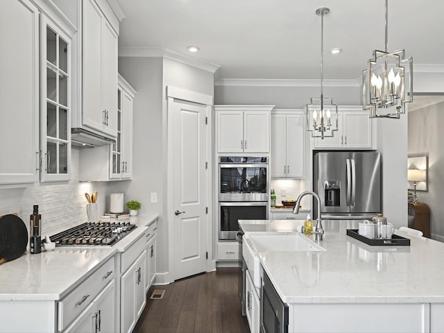 kitchen with a sink, appliances with stainless steel finishes, white cabinets, and an island with sink