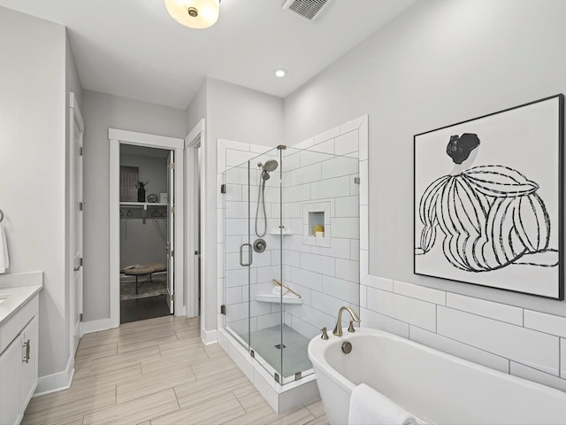 full bath with vanity, a shower stall, a soaking tub, and visible vents