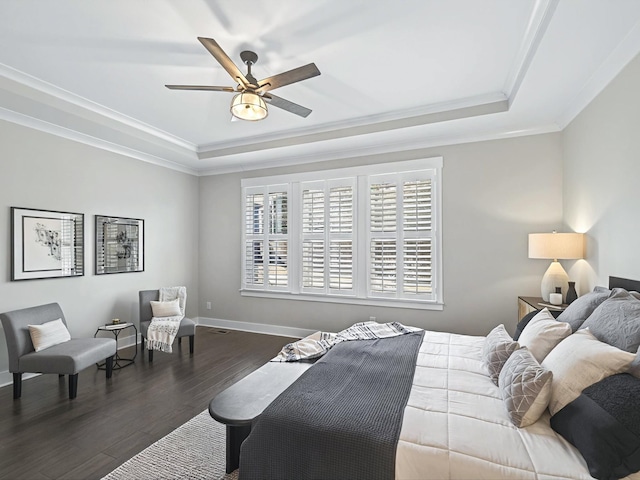 bedroom featuring a tray ceiling, dark wood-style floors, baseboards, and ornamental molding