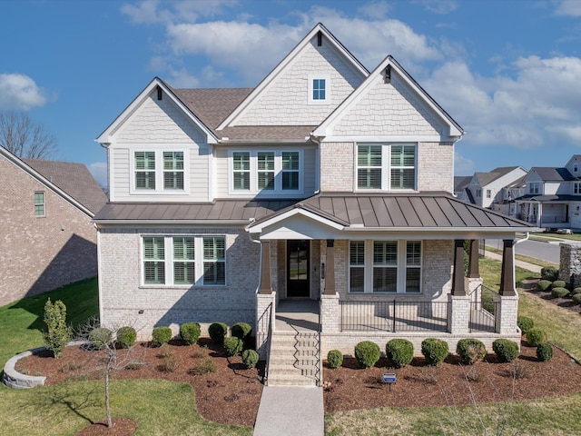 craftsman house with metal roof, brick siding, a porch, and a standing seam roof