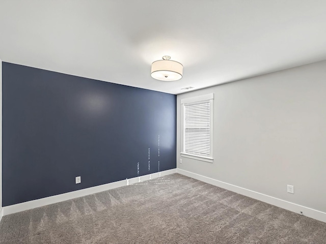 unfurnished room featuring baseboards, carpet floors, and visible vents