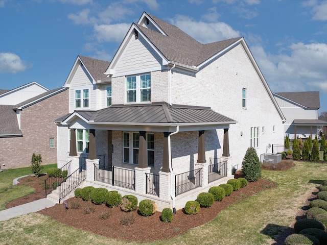 craftsman house with brick siding, a shingled roof, a porch, metal roof, and a standing seam roof