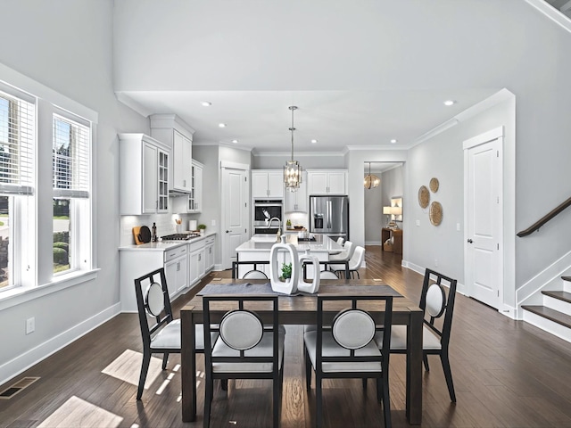 dining area with visible vents, dark wood-style floors, baseboards, a chandelier, and stairs