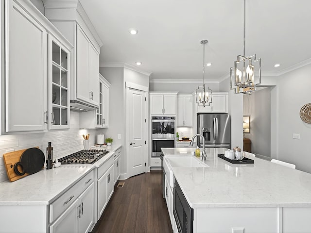 kitchen with dark wood-style flooring, decorative backsplash, white cabinets, appliances with stainless steel finishes, and crown molding