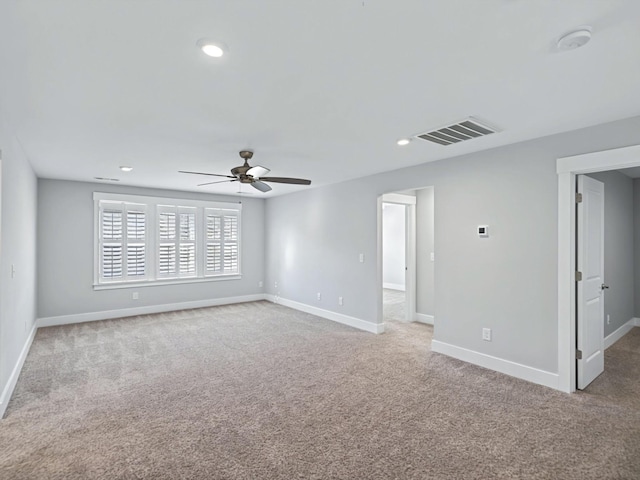 spare room featuring baseboards, visible vents, and light carpet