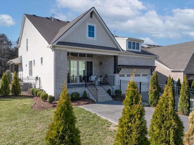 view of front of property with a front yard, fence, an attached garage, covered porch, and brick siding