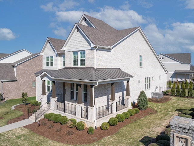 view of front of property with brick siding, a shingled roof, a porch, metal roof, and a standing seam roof