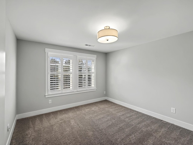 carpeted empty room with visible vents and baseboards