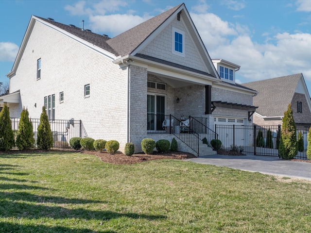 view of front facade with a front lawn, fence, and brick siding