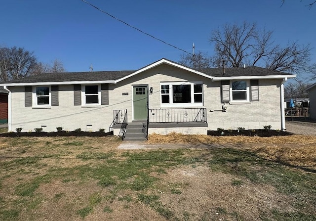 view of front of property featuring crawl space, brick siding, a front yard, and a shingled roof