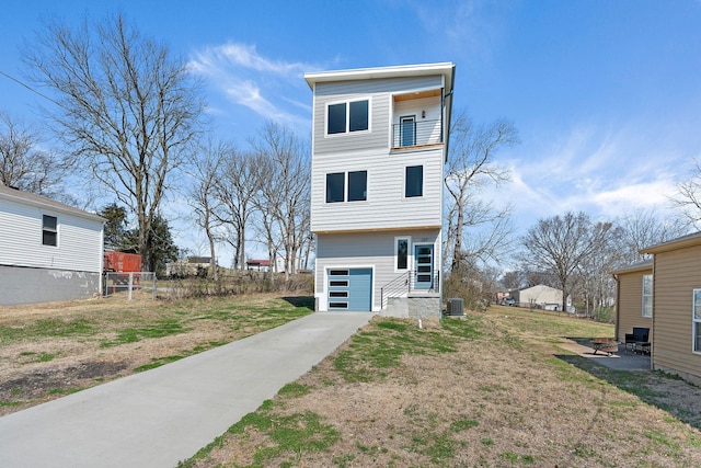 back of property featuring a balcony, cooling unit, fence, a garage, and a lawn