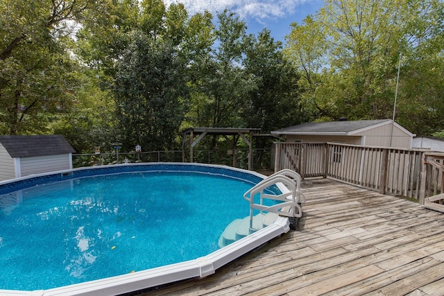 view of pool with an outbuilding, a fenced in pool, a wooden deck, and a storage shed