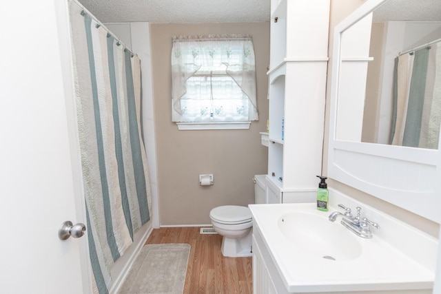 bathroom featuring a shower with curtain, a textured ceiling, wood finished floors, and toilet