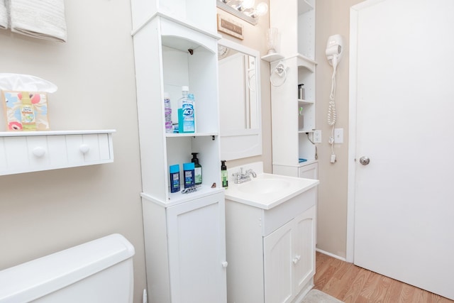 bathroom featuring vanity, toilet, and wood finished floors