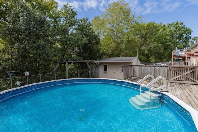 view of swimming pool featuring a fenced backyard, a fenced in pool, an outdoor structure, and a deck