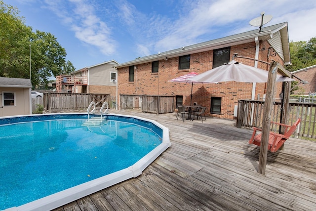 view of pool with a fenced in pool, a deck, outdoor dining space, and fence