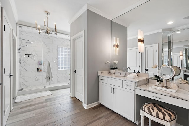 bathroom featuring wood finished floors, a marble finish shower, crown molding, baseboards, and vanity