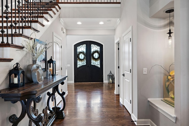 entryway featuring ornamental molding, dark wood finished floors, french doors, arched walkways, and baseboards