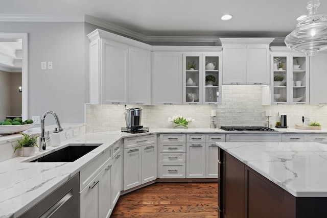 kitchen with white cabinetry, gas stovetop, a sink, stainless steel dishwasher, and crown molding