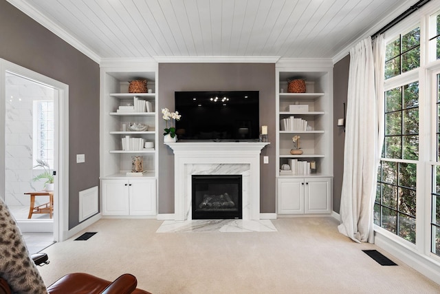 living area with visible vents, built in shelves, light colored carpet, and wood ceiling