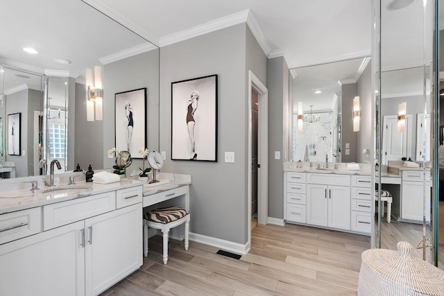 bathroom featuring two vanities, ornamental molding, a sink, wood finished floors, and a shower stall