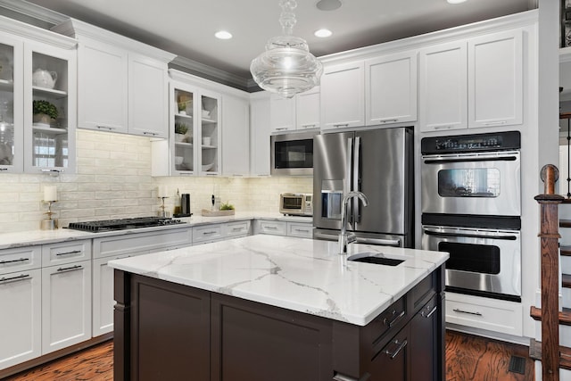 kitchen with glass insert cabinets, dark wood-style floors, appliances with stainless steel finishes, white cabinets, and decorative backsplash