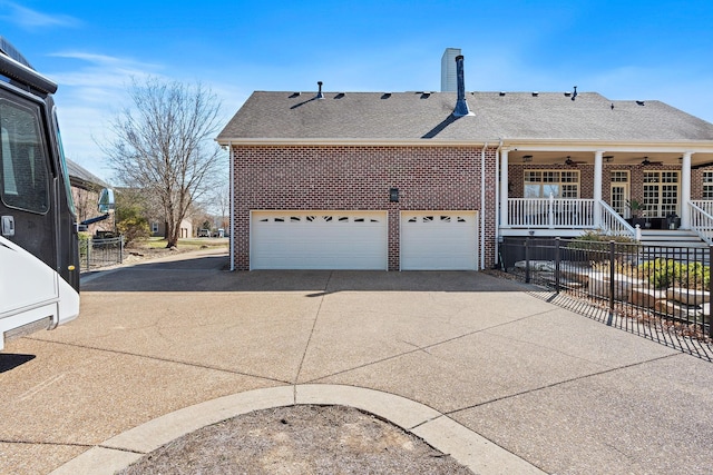 exterior space with brick siding, concrete driveway, ceiling fan, and fence