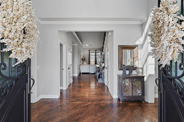 foyer with crown molding, baseboards, and wood finished floors