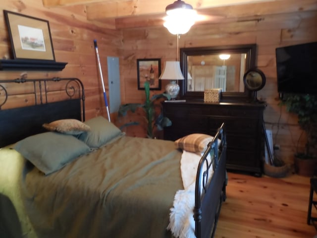 bedroom with log walls and wood finished floors