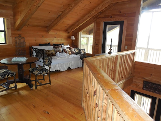 bedroom with wooden walls, wooden ceiling, vaulted ceiling with beams, and wood-type flooring