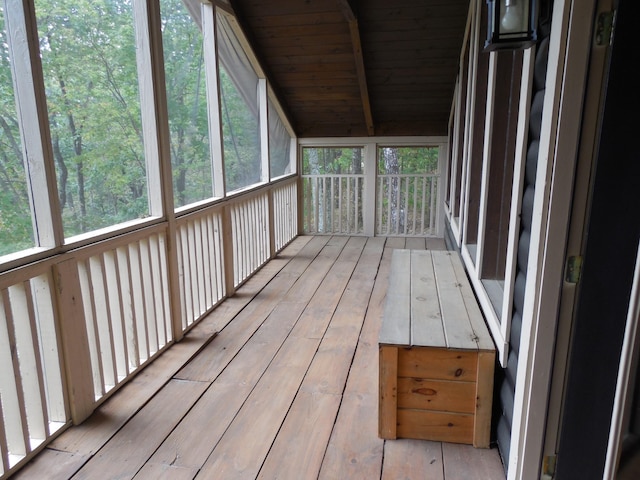 unfurnished sunroom with lofted ceiling with beams