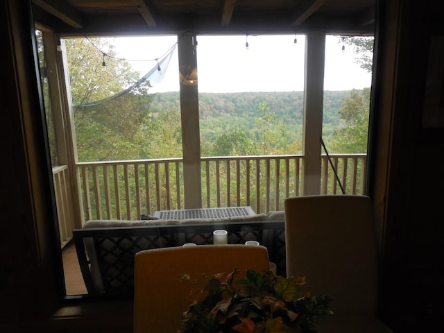 sunroom / solarium featuring a view of trees