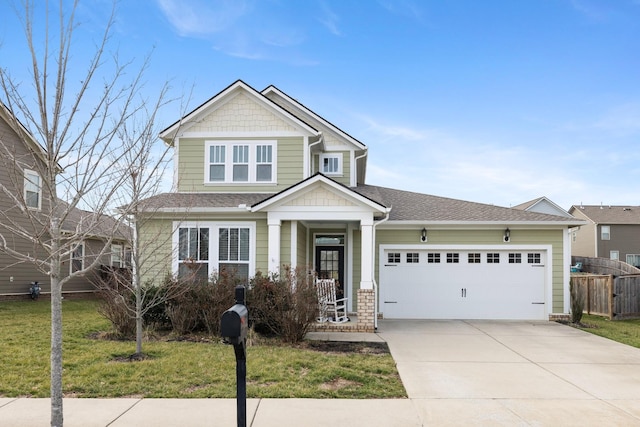 craftsman house with driveway, a shingled roof, fence, a front yard, and an attached garage