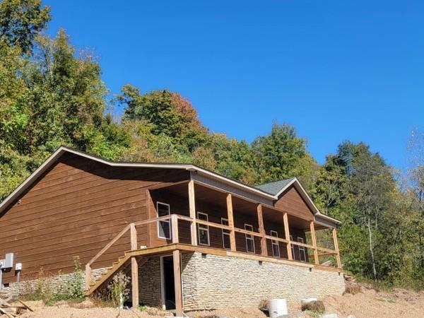 back of property with an outdoor structure, stone siding, and an exterior structure