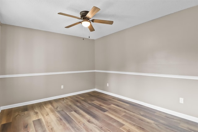 spare room with ceiling fan, baseboards, and wood finished floors