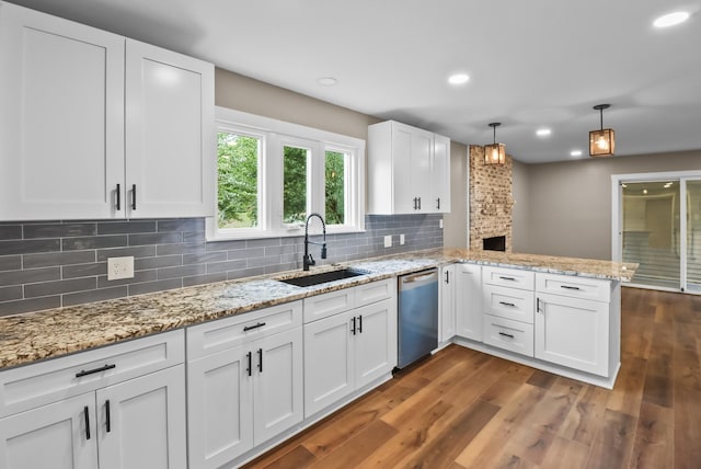 kitchen featuring a sink, a peninsula, white cabinets, dishwasher, and dark wood-style flooring