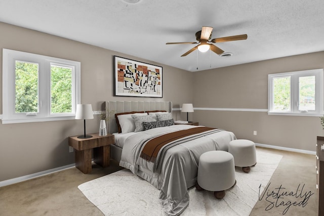 carpeted bedroom featuring visible vents, baseboards, a textured ceiling, and a ceiling fan