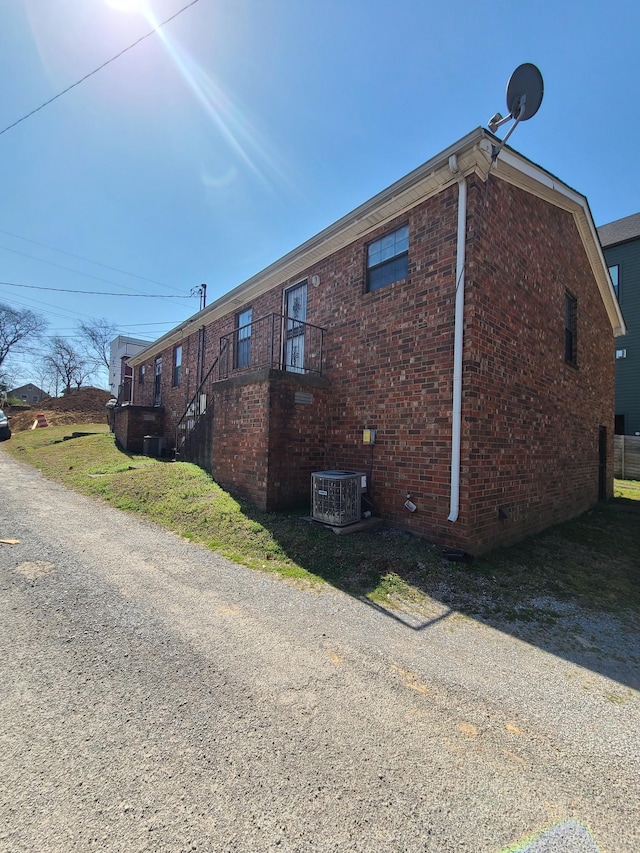 view of home's exterior with cooling unit and brick siding