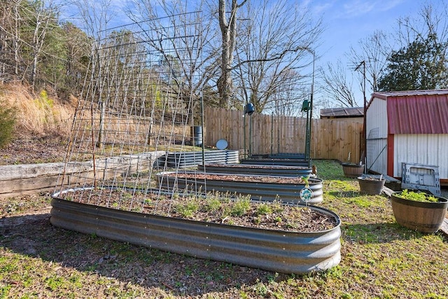 view of yard with an outbuilding, a shed, fence, and a garden