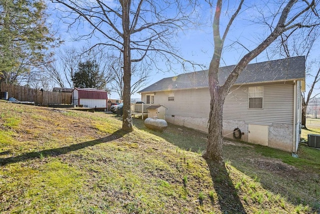 view of yard with an outdoor structure, a shed, and fence