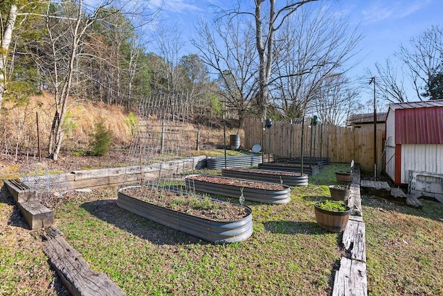 view of yard with an outdoor structure, a storage shed, a vegetable garden, and fence