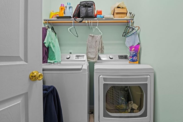 clothes washing area with washer and clothes dryer and laundry area