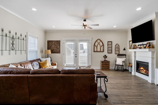 living room with dark wood-style floors, a glass covered fireplace, french doors, and a wealth of natural light