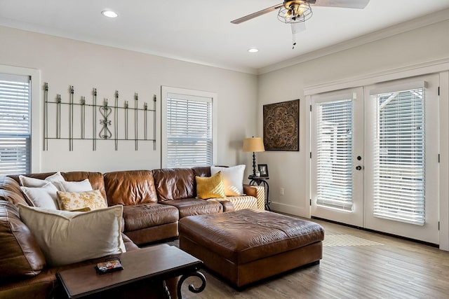 living room with a ceiling fan, wood finished floors, recessed lighting, ornamental molding, and french doors