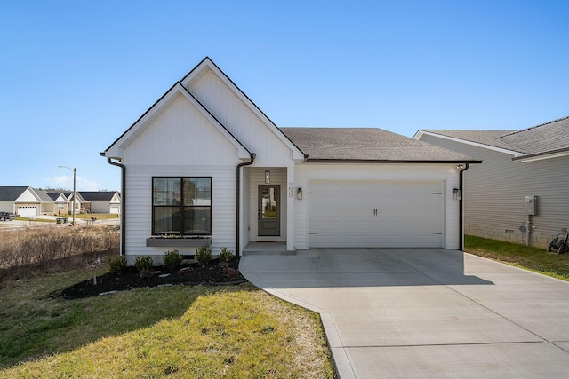 view of front of home with a front yard, an attached garage, driveway, and a shingled roof