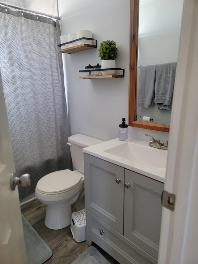 full bathroom featuring toilet, shower / bath combo, wood finished floors, and vanity