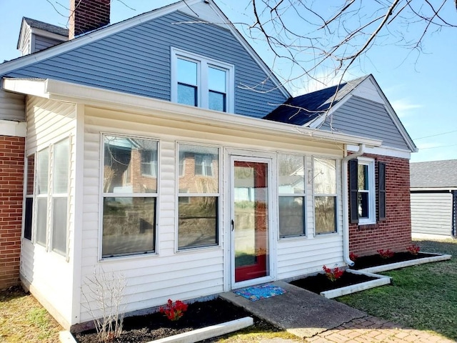 view of side of property with brick siding and a chimney